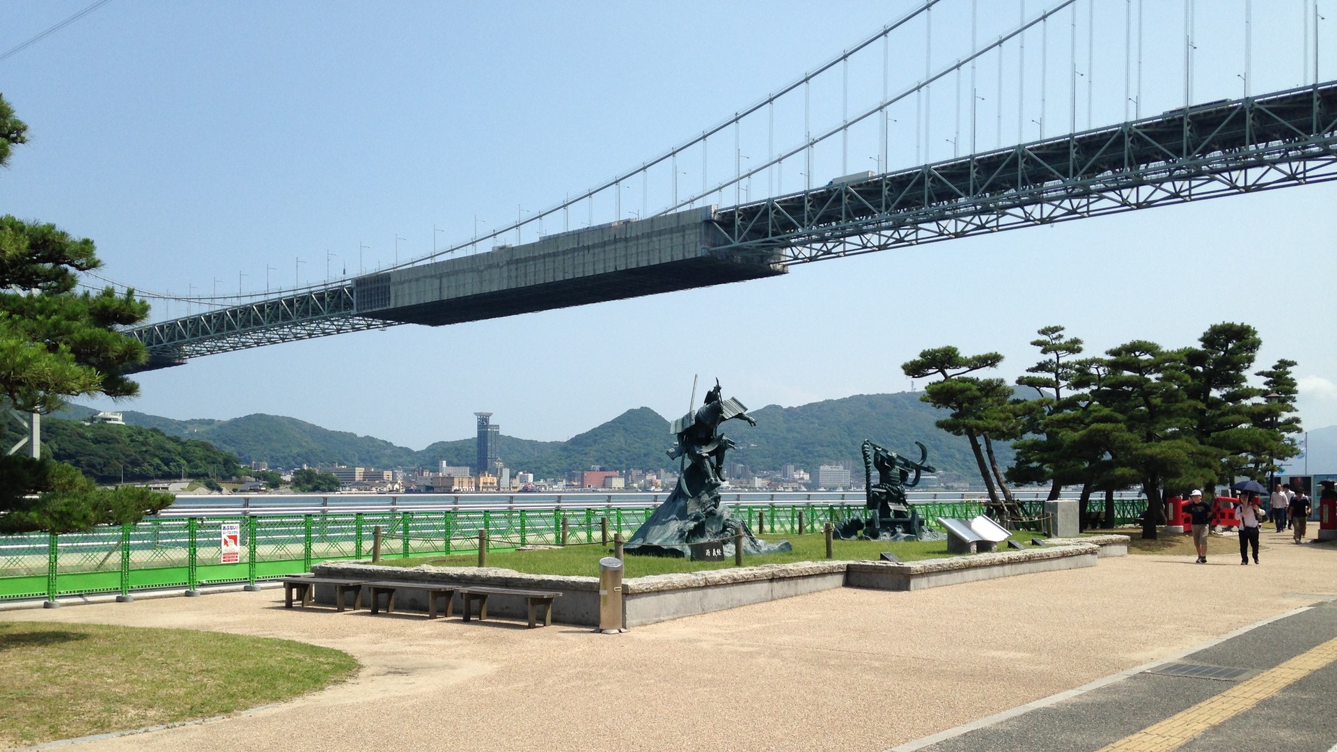 関門橋の真下、みもすそ川公園に立つ源義経・平知盛の像と関門海峡・門司港の眺め